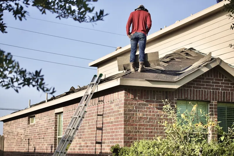 Professional roofer working on a residential roof in Peabody Town Center